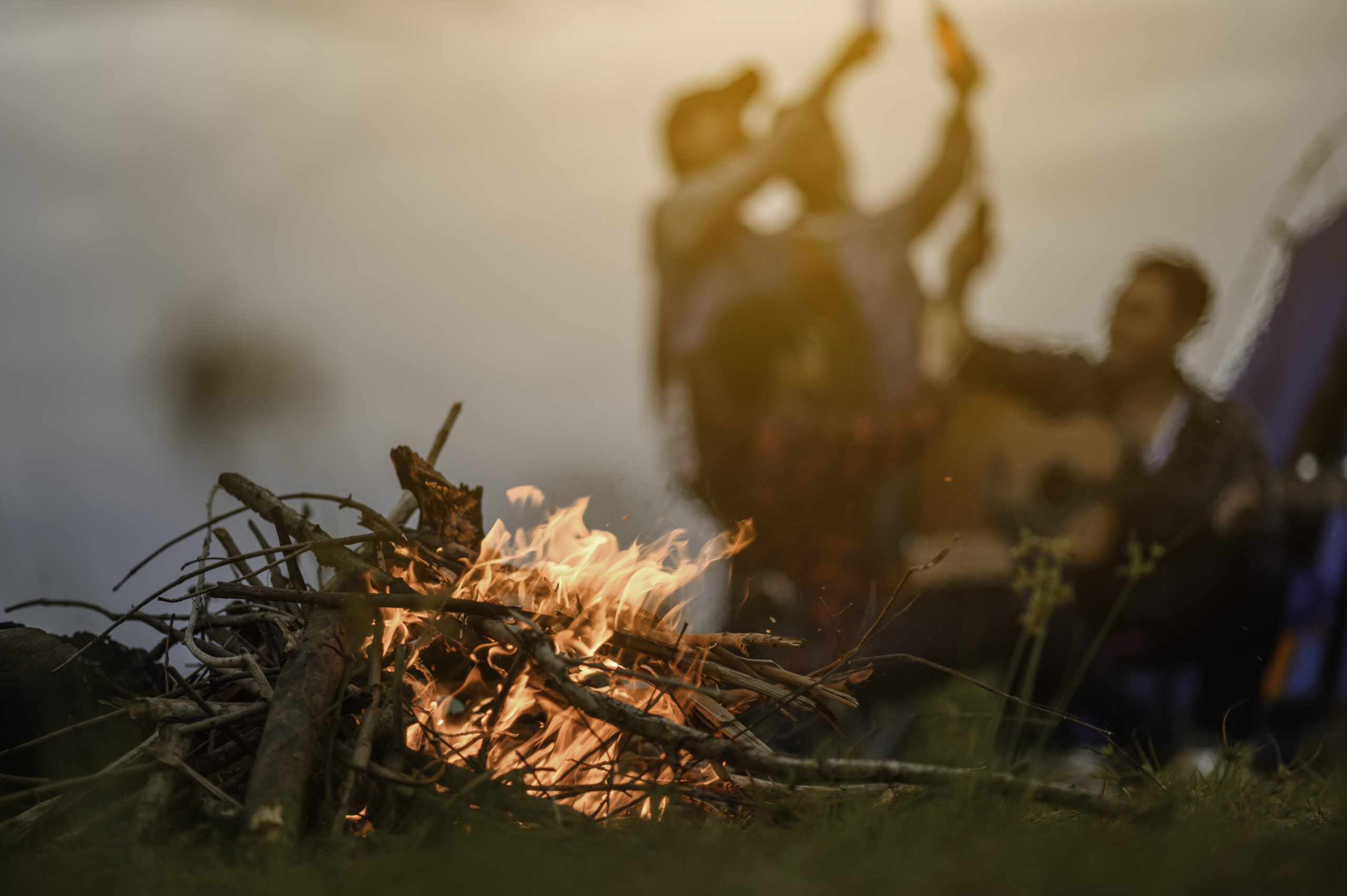 Group of friends camping.They are sitting around fire camp.